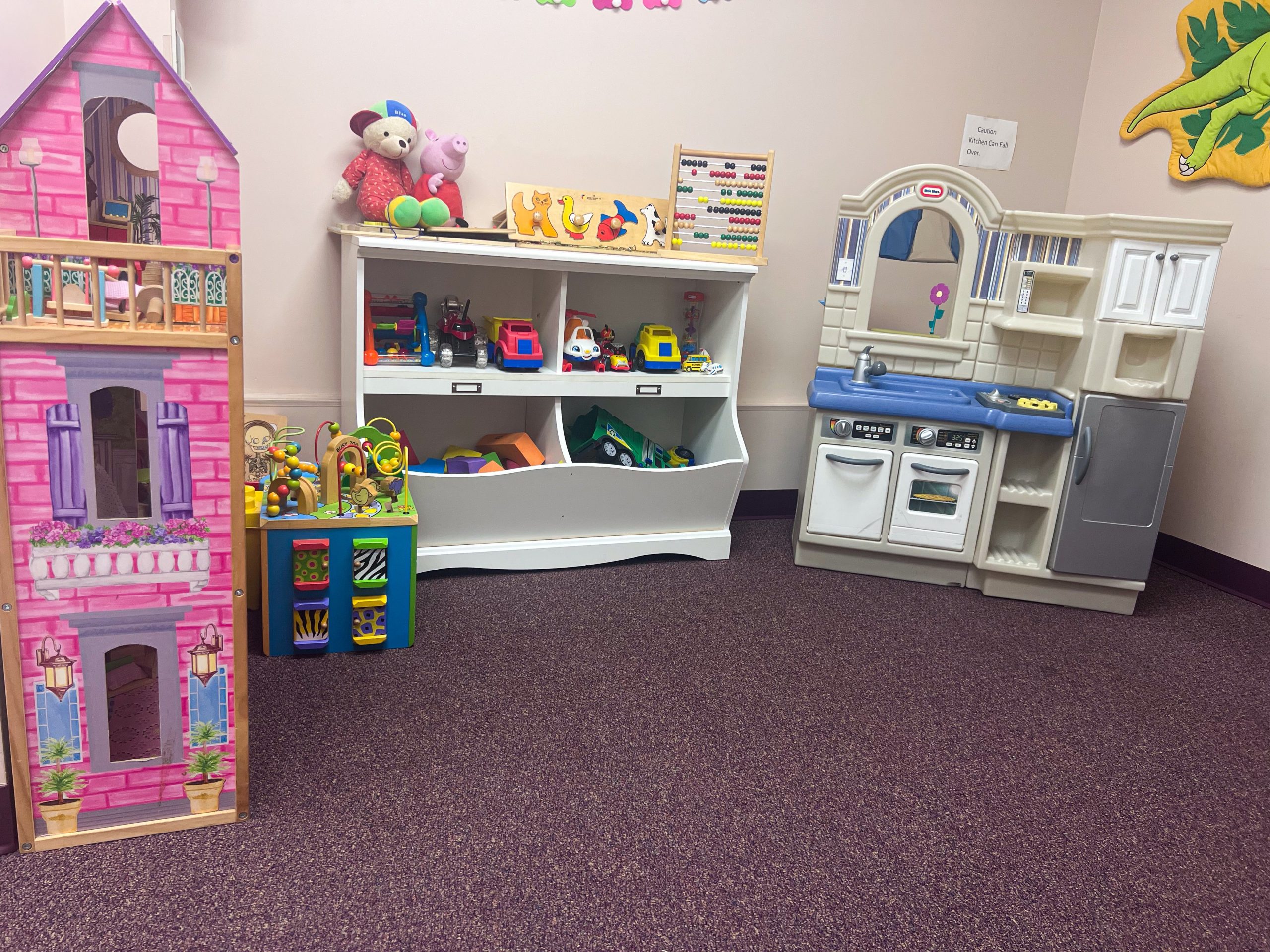 Kids play area with play kitchen, doll house, and books